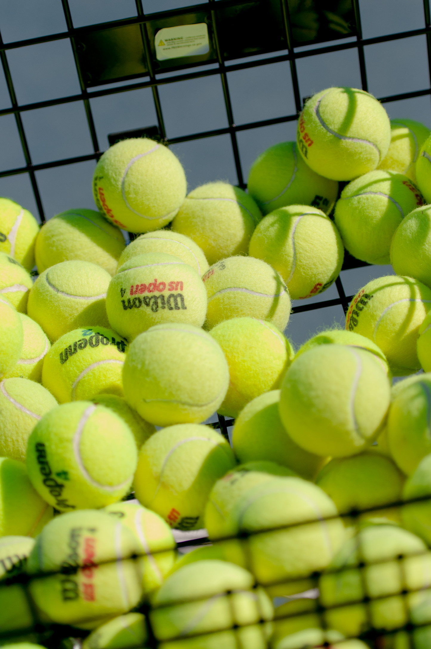 A bucket of tennis balls used at clinics