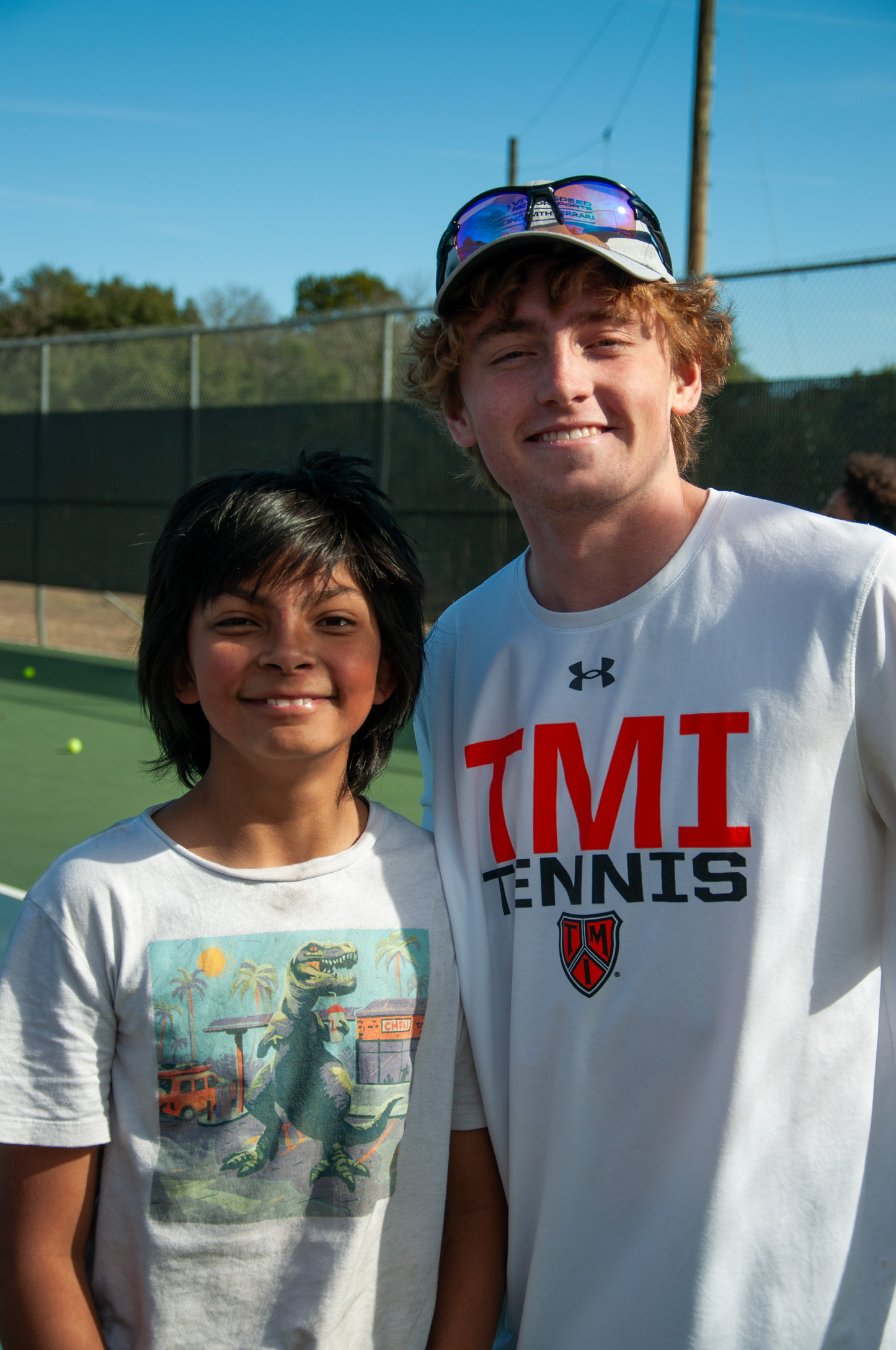 A coach and young player smiling on court