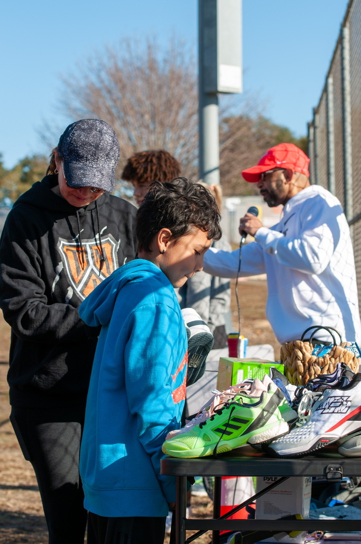 Kids picking out refurbished rackets at a clinic